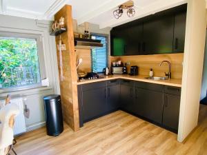 a kitchen with black cabinets and a window at Trendy House Hattem nr4 in Hattemerbroek