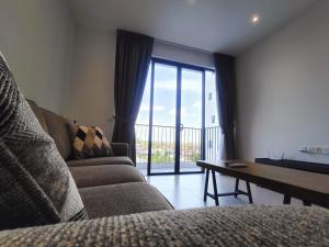 uma sala de estar com um sofá, uma mesa e uma janela em Armadale Galacity Minimalist 3 Bedrooms Entire Apartment em Kuching