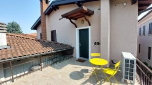 eine Terrasse mit einem gelben Tisch und Stühlen vor einem Haus in der Unterkunft Casa Franciacorta in Gussago