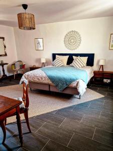a bedroom with a bed and a table and chairs at Ferienhaus "Entenhaus" im Gutshaus De La Fontaine in Feilsdorf +11 photos