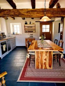 kuchnia i jadalnia z drewnianym stołem w obiekcie Ferienhaus "Entenhaus" im Gutshaus De La Fontaine w mieście Feilsdorf