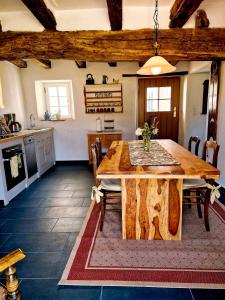 a kitchen and dining room with a wooden table at Ferienhaus "Entenhaus" im Gutshaus De La Fontaine in Feilsdorf