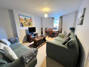 een woonkamer met 2 banken en een televisie bij 2 Bedroom Apartment ST9A, Ryde, Isle of Wight in Ryde