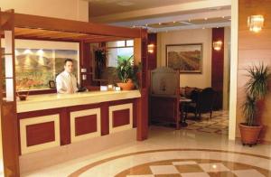 a man sitting at a bar in a hotel lobby at Elena Hotel in Kozani