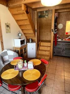 a kitchen with a wooden table and chairs in a room at la p'tit marennaise in Marennes