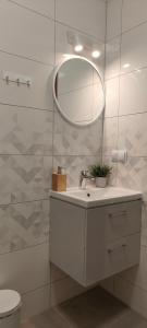een witte badkamer met een wastafel en een spiegel bij Hajlanderka in Bustryk