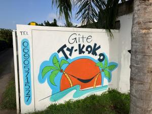 Un signe pour un cadeau k kxk sur un mur dans l'établissement Gîte Ty Koko, à Saint-François