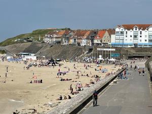 a group of people on a beach with houses at Mobil-Home VUE sur MER in Le Portel