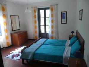 a bedroom with a blue bed and a window at Vila with private pool in Licciana Nardi