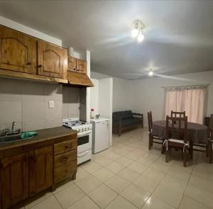 聖拉斐爾的住宿－Deptos Av Moreno，带水槽和桌子的厨房以及带炉灶的厨房。