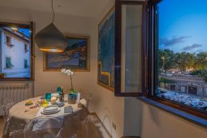 una sala da pranzo con tavolo e una grande finestra di The Architect Suite - Canals View a Livorno
