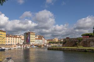 um rio com edifícios e barcos numa cidade em The Architect Suite - Canals View em Livorno