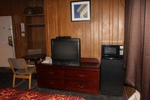 a room with a tv on a dresser with a microwave at Scottish Inn - Madison Heights in Madison Heights