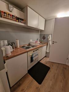 una pequeña cocina con fogones y nevera. en Mertens Zimmervermietung, en Hamburgo