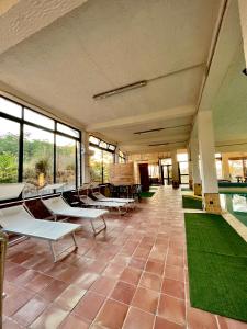 a room with tables and chairs and a pool at Agriturismo Villa Assunta in Santa Caterina Villarmosa