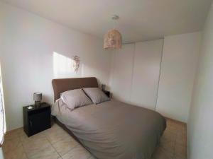 a small bedroom with a bed with a night stand at Appartement centre ville à deux pas de la plage in Le Grau-du-Roi