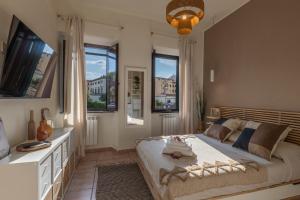 The Architect Suite - Canals View في ليفورنو: غرفة نوم بسرير ومكتب ونوافذ