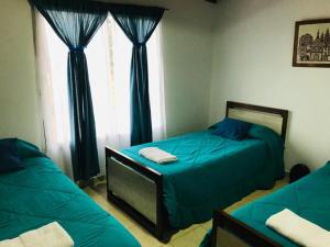 1 dormitorio con 2 camas y ventana en Casita en plottier en Plottier