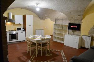 een keuken met een tafel en witte kasten in een kamer bij [Perugia Center] Typical apartment in Perugia