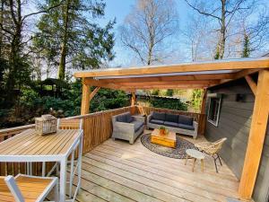 a wooden deck with a pergola and a table at Trendy House Hattem nr4 in Hattemerbroek