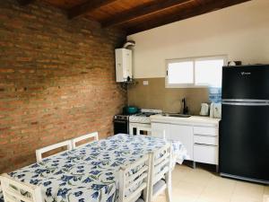 a kitchen with a table and a black refrigerator at Casita en plottier in Plottier +9 photos
