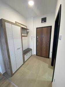 a room with a closet and a door with a bench at Apartman MI in Banja Koviljača