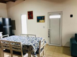 a dining room with a table and a refrigerator at Casita en plottier in Plottier