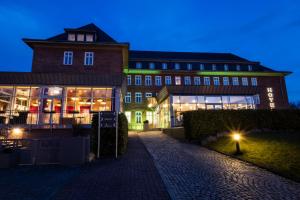 a large building with lights in front of it at Hotel am Schlosspark in Güstrow
