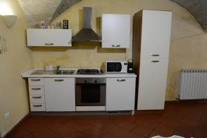 een keuken met witte kasten, een fornuis en een magnetron bij [Perugia Center] Typical apartment in Perugia