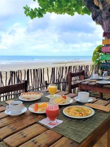 una mesa con comida y bebida en la playa en Pousada Ponta Da Pedra, en Jericoacoara