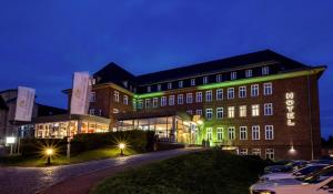 un edificio con luz verde en su lateral en Hotel am Schlosspark, en Güstrow