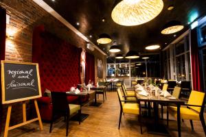 a dining room with tables and chairs and a sign at Hotel am Schlosspark in Güstrow +73 photos