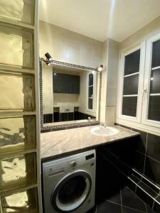 a bathroom with a washing machine and a sink at Bel appartement proche de Paris in Colombes +5 photos