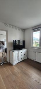 een woonkamer met een witte kast en een raam bij Studio Apartment Urban Haven in Sarajevo