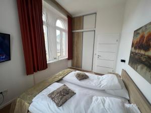 een slaapkamer met een wit bed en een raam bij Apartments Elfie in Sarajevo