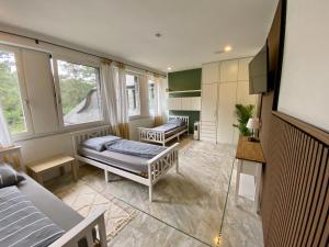a room with two beds and a tv and windows at Villa Arche 2 in Neuenkirchen-Vörden