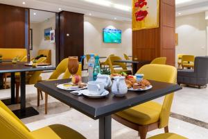 a cafeteria with tables and chairs with food on them at Hotel Hammamet in Alger