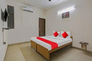 a bedroom with a bed with red pillows and a tv at OYO Flagship Hotel Stanley Falls in Gurgaon