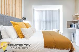 a bedroom with a bed with yellow and white pillows at SCA - Best Located Studio - CR1 in Birmingham