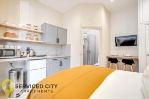 um quarto com uma cama com um cobertor amarelo em SCA - Best Located Studio - CR1 em Birmingham