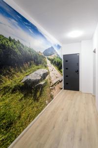 a room with a wall mural of a river and mountains at Mega widok 5 in Szklarska Poręba