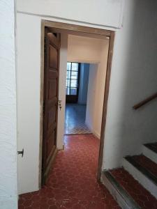 een hal met een deur en een rode tegelvloer bij Villa des Lucioles 2 in Annot