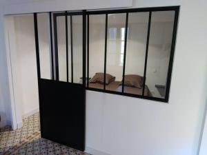 a black glass cabinet with a mirror on a wall at Villa des Lucioles 2 in Annot