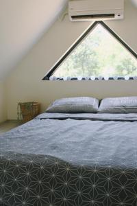 a bedroom with a bed with a large window at Tiny House Kosmaj in Sopot