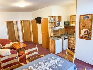 a kitchen and dining room with a table and chairs at Apartmany Jasna in Demanovska Dolina +27 photos