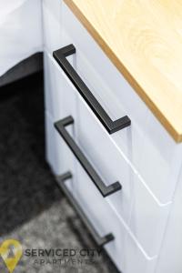 a drawer with black handles on a white kitchen cabinet at SCA - Spacious Loft Studio - CR7 in Birmingham