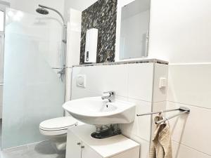 ein weißes Bad mit einem Waschbecken und einem WC in der Unterkunft Wellness Apartment - Sauna - 3 Schlafzimmer - 6 Personen - Zentrum in Hannover