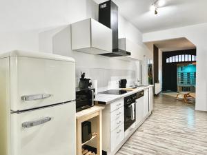 Il comprend une cuisine équipée d'appareils électroménagers blancs et d'un réfrigérateur blanc. dans l'établissement Wellness Apartment - Sauna - 3 Schlafzimmer - 6 Personen - Zentrum, à Hanovre