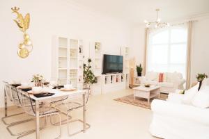 a white living room with a table and a couch at An Exclusive 2BR Retreat Experience Yas Island Bliss in Abu Dhabi