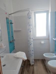 a bathroom with a sink and a toilet and a window at Il Mirto Residence in Marina di Camerota +42 photos